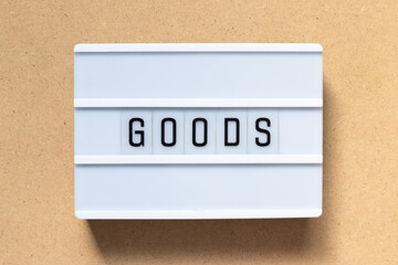 White lightbox with word goods on wood background