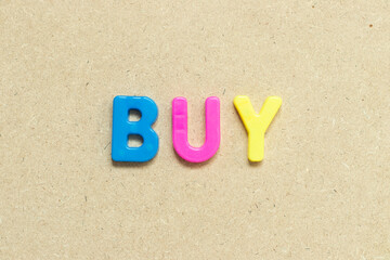 Color alphabet letter with word buy on wood background