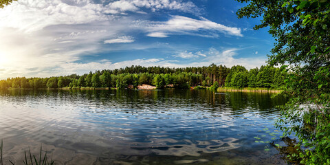 Lake in the woods with pine trees on the shore for summer vacation.
