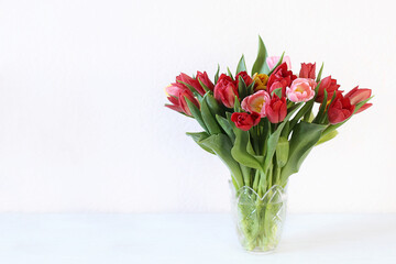 Beautiful bouquet with multicolored tulips in vase copy space