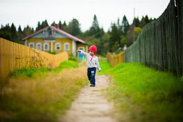 a little boy walks through the village, selective focus