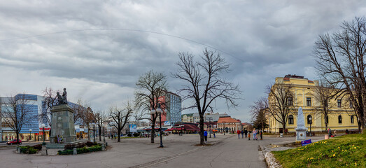 The city of Zajecar in eastern Serbia. The downtown, an old marble stone fountain, war heroes monument, promenade and town square during late afternoon. 