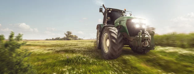 Foto auf Acrylglas Traktor Traktor fährt auf einem Feldweg neben einem Feld