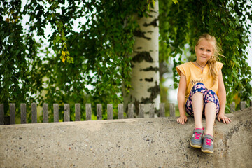 girl sitting next to a birch tree, selective focus 