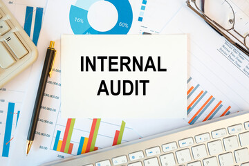 INTERNAL AUDIT is written in a document on the office desk, diagram and keyboard