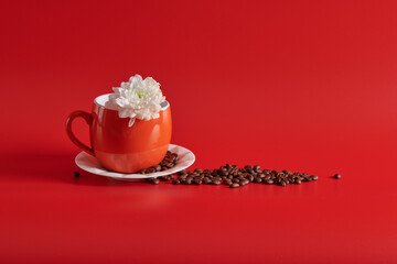 orange cup and saucer with flower on red background