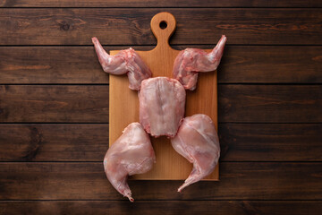 fresh red whole rabbit meat on a wooden cutting board, copy space