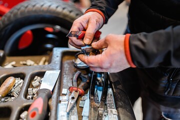 Mechanic in a car workshop taking working tools.