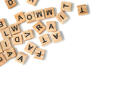 Top view of square wooden tiles with the English alphabet scattered on a white background with space for text. The concept of thinking development, grammar.