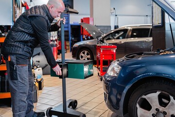 Fototapeta na wymiar Mechanic in a car repair shop checking the lights of a vehicle