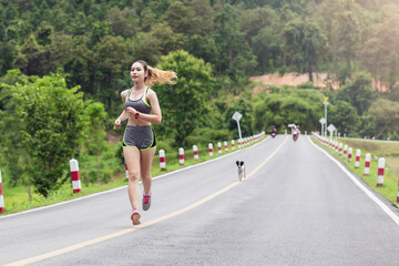 Fototapeta premium Woman in sportswear running and wearing headphones in the park.