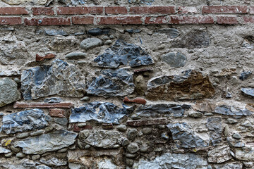 Old grungy retro dirty dusty brick wall of ancient city. Uneven pitted peeled surface brickwork of cellar worn. Ruined shabby stiff blocks. Hard solid messy ragged holes brickwall for 3D grunge design