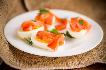 halves of boiled eggs with pieces of salted salmon