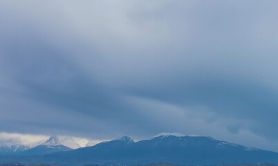 Fototapeta na wymiar Grandi nuvole sulle cime delle montagne appennine