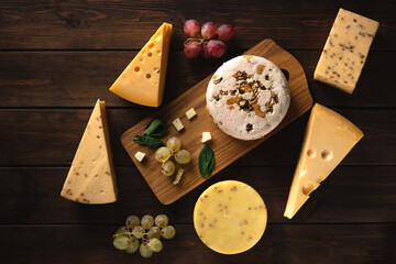 different types of cheese on a cutting board top view