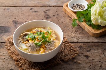 Clear soup with Chinese Cabbage,Minced Pork and egg in white bowl.