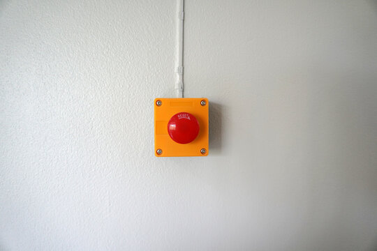 Fire alarm push button on white cement wall