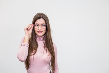 Beautiful young smiling woman with glasses standing over white wall