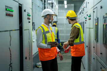 Maintenance engineers inspect relay protection system in control room of a modern thermal power...