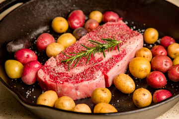 Red meat steak in a cast iron pan with potatoes