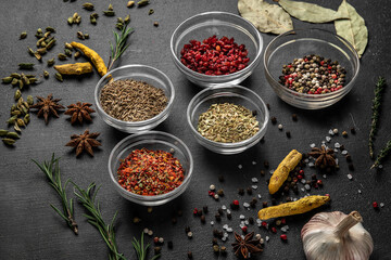 various spices on a gray background. seasoning in glass cups side view