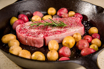 Red meat steak in a cast iron pan with potatoes