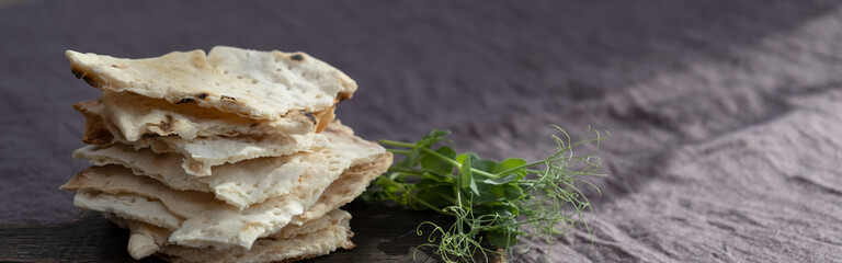 Homemade matzo with microgreen peas. Unleavened flatbread bread. Pesah celebration concept. Jewish Passover background. Pita.