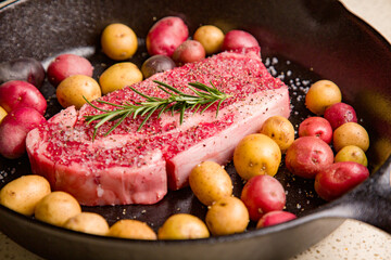 Red meat steak in a cast iron pan with potatoes