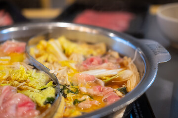 Sliced meat and vegetables boiled in double flavor hot pot.