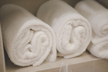 Fototapeta na wymiar Rolled up white towels at hotel