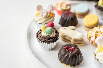 cute colorful spring easter egg shape cake tartlet muffin cupcake with yellow tulips easter concept 