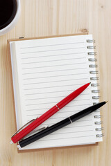 Notepad with two pens and coffee