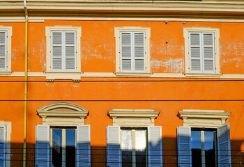 orange facade of the baroque building with blue windows and shutters. European architecture...