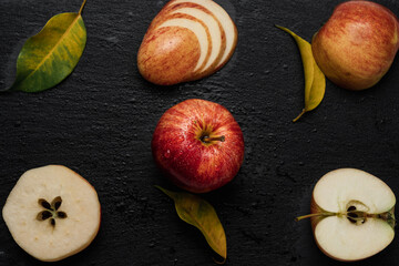 Red an yellow apples cut in different ways with leaves