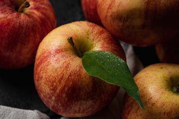 Red an yellow apple with a leaf close up shot on a black table