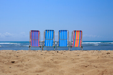 Empty beach chairs in the blue sky - obrazy, fototapety, plakaty