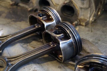 Old worn out engine pistons. The pistons are dirty and oily. One of the pistons is in focus, the...