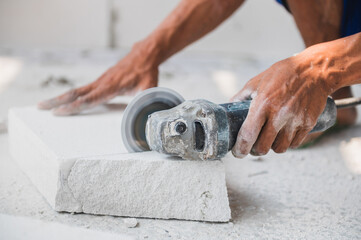 worker cutting bricks in construction site