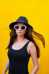 American flat vertical photo of a young caucasian woman on yellow background,