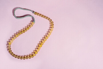 An amber citrine stone gemstone sunshine female necklase made of spherical transparent  beads in a backlight.  
