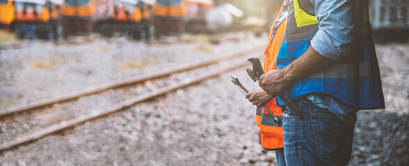 Hands of team engineer holding wrench for repair working on train garage site, for banner cover design.