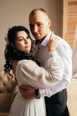 Husband and wife couple hugging at the photo session in studio. Wedding married bride and groom celebrate their engagement. Procreation romantic amazing lovers newlyweds indoor, copy space.
