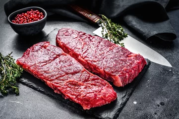 Tuinposter Marble beef Denver steak with herbs. Organic meat. Black background. Top view. © Vladimir