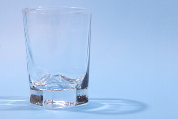 Empty glass on blue background. Studio photo