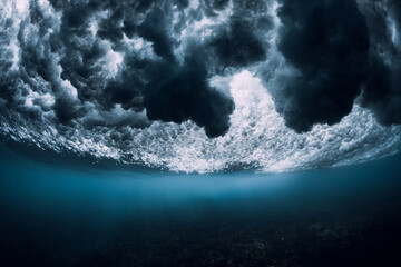 Wave underwater with foam, bubbles and sun light. Transparent ocean in underwater