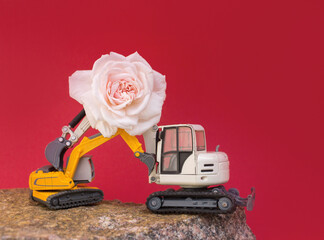 big pink rose flower on the arrow of two toy construction vehicles - excavator. business - congratulations, holiday builder day. postcard for construction business. romance in the world of cars