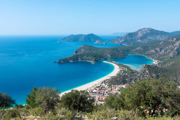 Panoramic aerial view of blue lagoon and sand beach in Oludeniz, Fethiye, Turquoise Coast of southwestern Turkey. Sunny bright and clear blue sky in Oludeniz.