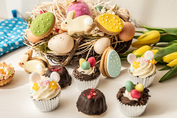 cute colorful spring easter egg shape cake tartlet muffin cupcake with yellow tulips easter concept 