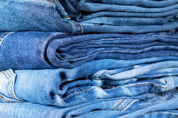Neatly folded denim clothing. Background on the theme of jeans.