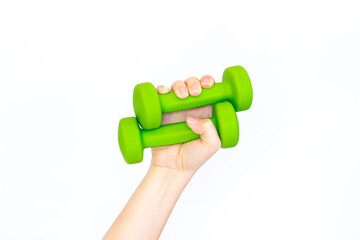 Two green dumbbells in a woman's hand isolated on white background. Sport equipment. Fitness concept. A call for a healthy lifestyle. Copy space for design